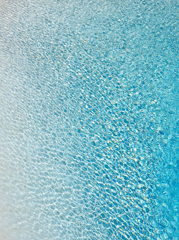 Slightly ruffled turquoise-coloured surface of water in a swimming pool