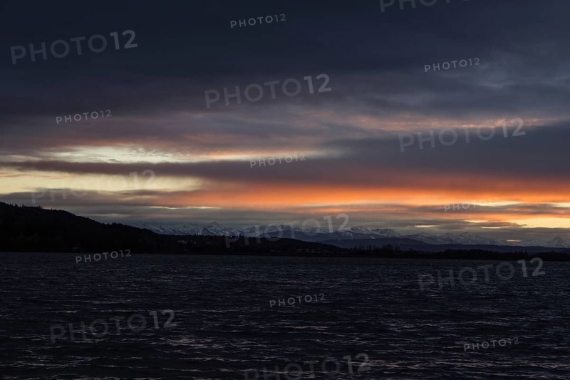 Foehn clouds over Lake Pilsen with snow-covered alpine mountains
