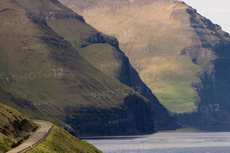 Road and mountains towering from the sea