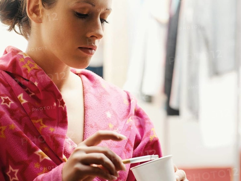 Woman wearing a bathrobe smoking a cigarette