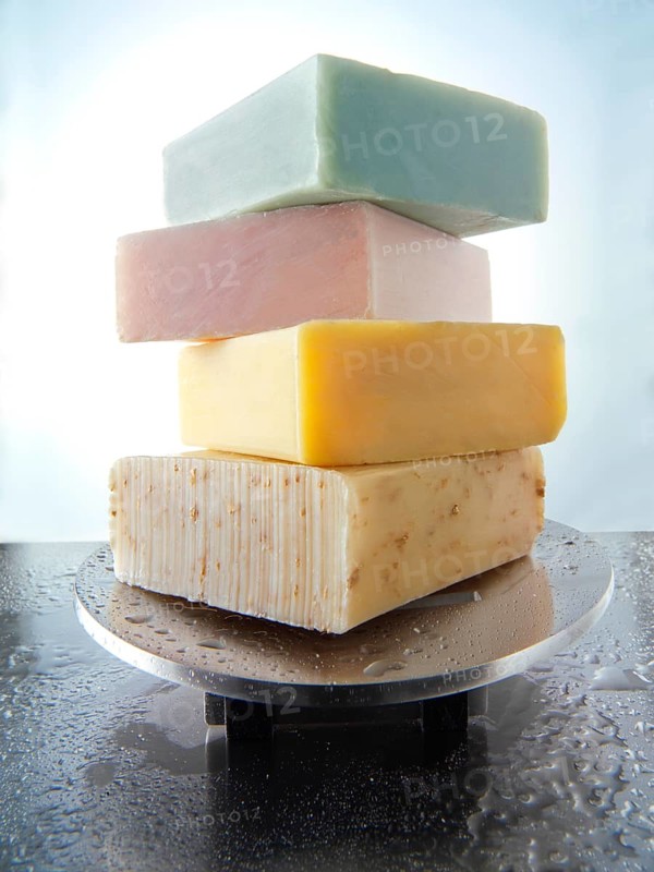 Bars of hand-made soaps piled on a soap dish