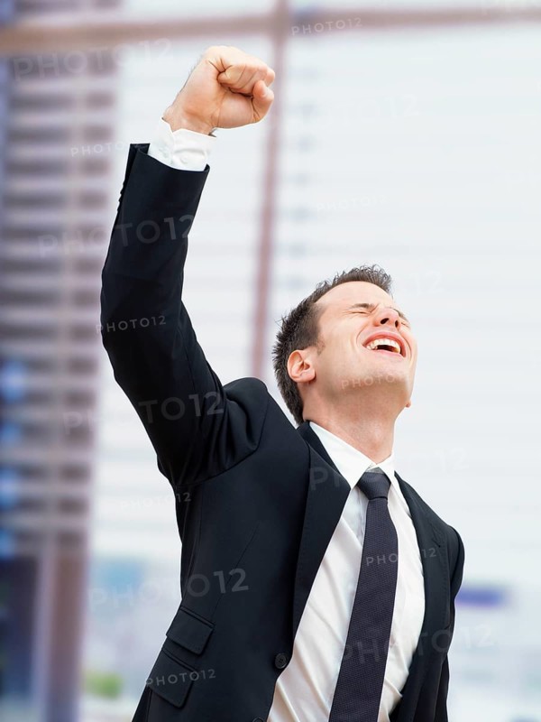 Businessman in an office cheering with a clenched fist