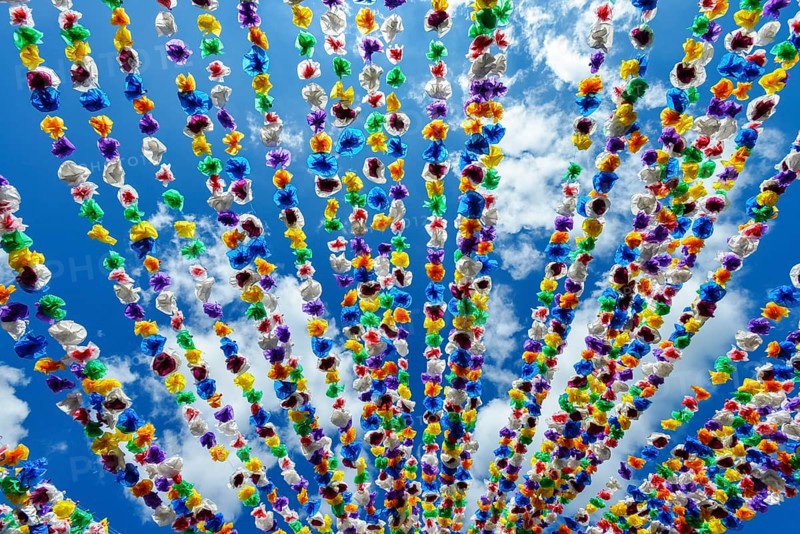 Colourful paper garlands against a blue sky