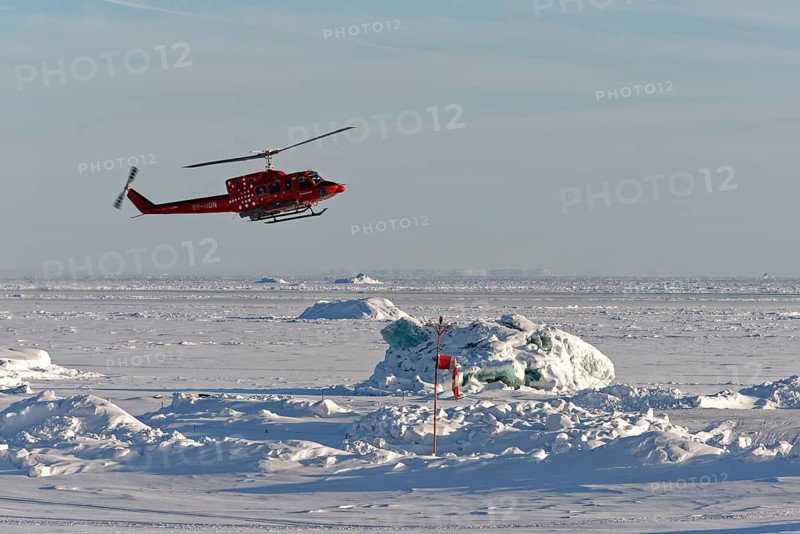 Helicopter lands on the helipad of Qeqertarsuaq