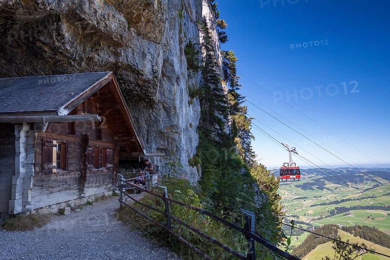 Wooden hut at the Wildkirchli Cave with a gondola of the Ebenalp cable car