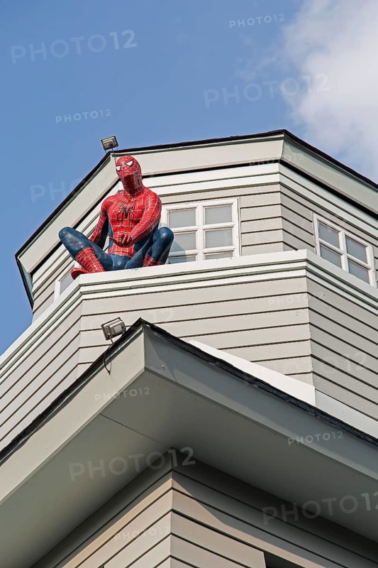Spiderman sitting on a house