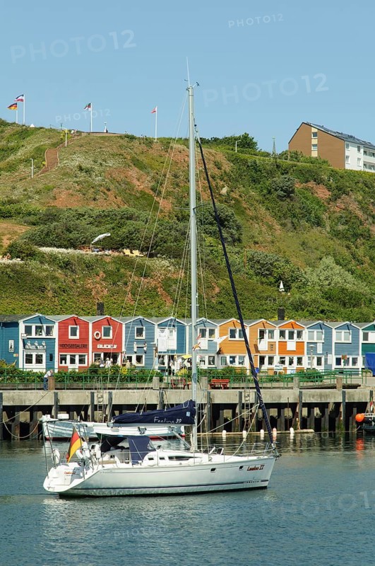 Sailing ship in the harbour of Heligoland or Helgoland in front of Hummerbuden or lobster shacks