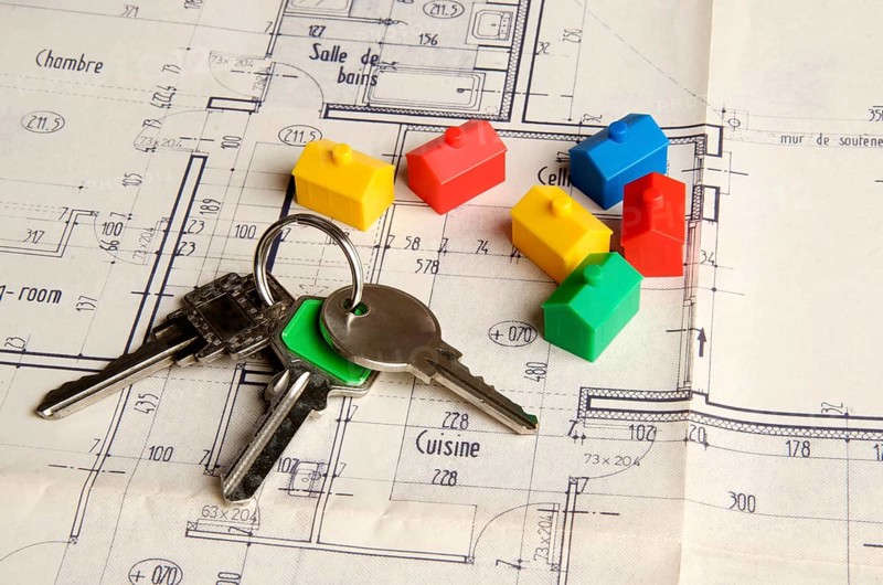 House keys and miniature houses on a construction plan