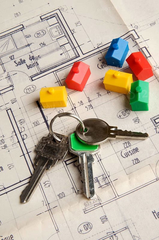 House keys and miniature houses on a construction plan