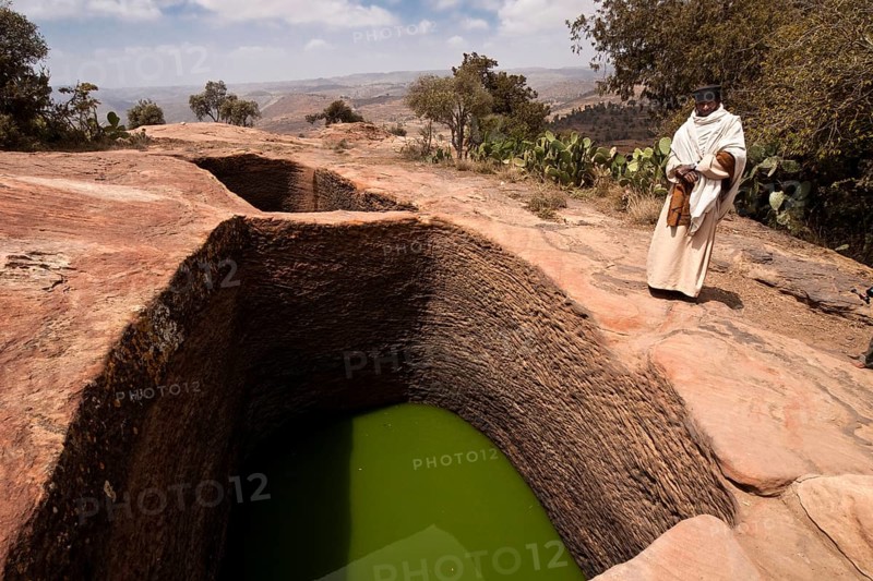 Orthodox monks at the holy water near the rock-hewn church of Mikael Imba