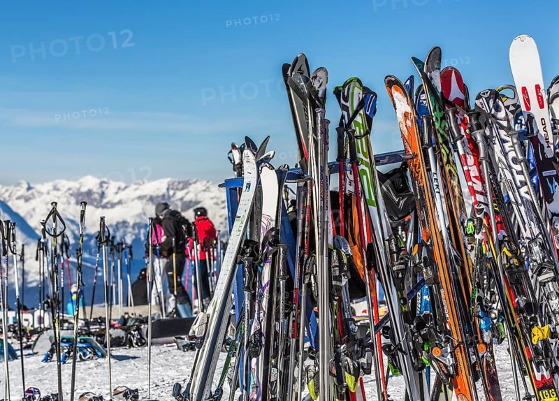 Skis and snowboards leaning against ski racks