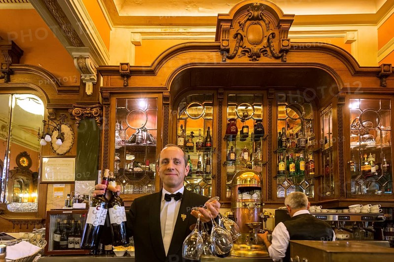 Waiter with wine bottles and glasses