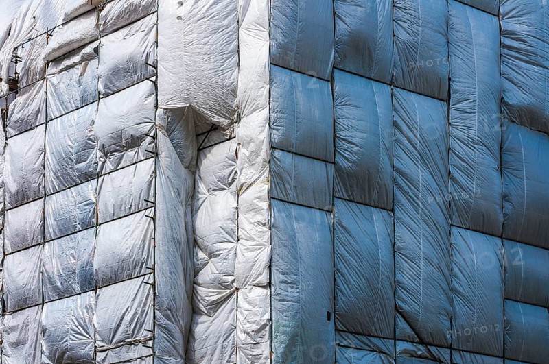 Scaffolding surrounded by a silver plastic tarp