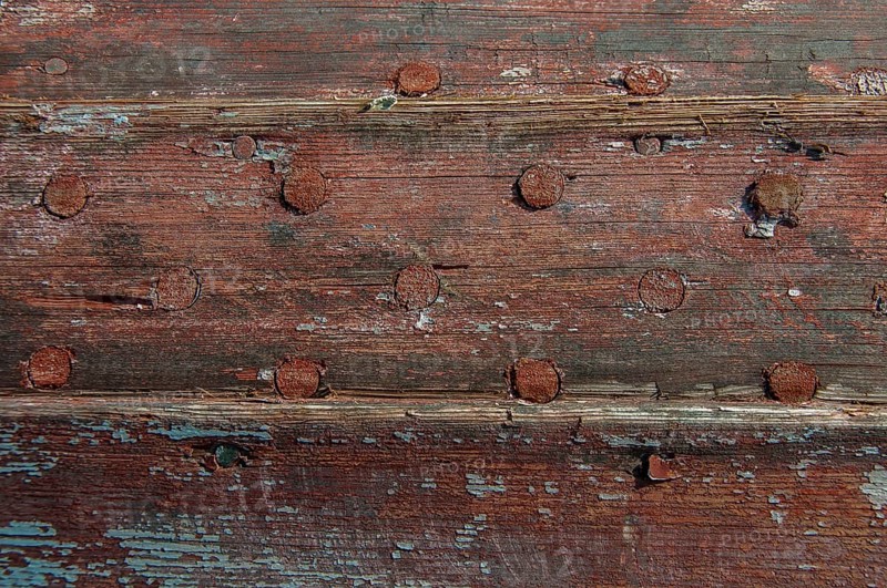 Weathered planks of a boat with residues of red paint