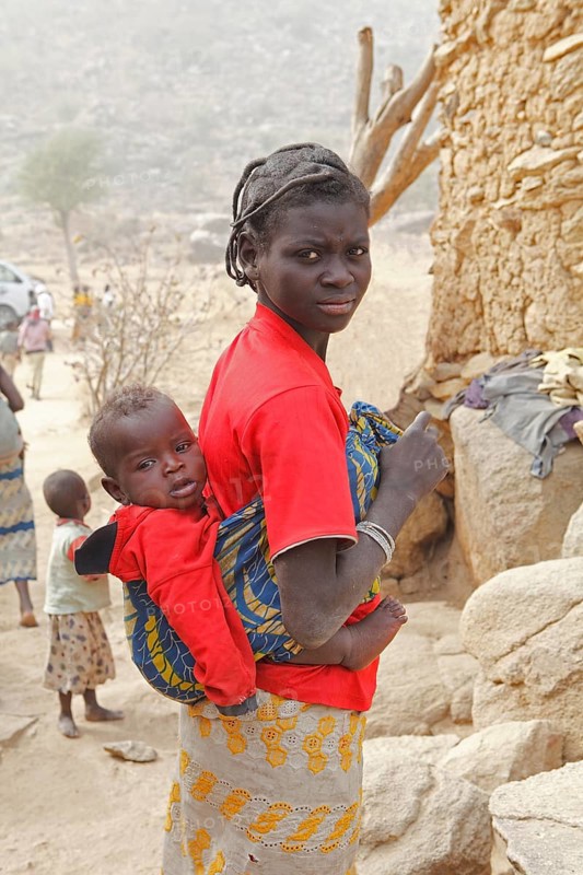 Woman of the Mafa ethnic group carrying a baby on her back