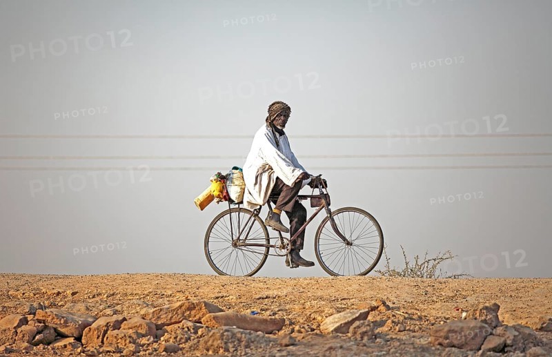 Local resident riding a bicycle at Maga Dam