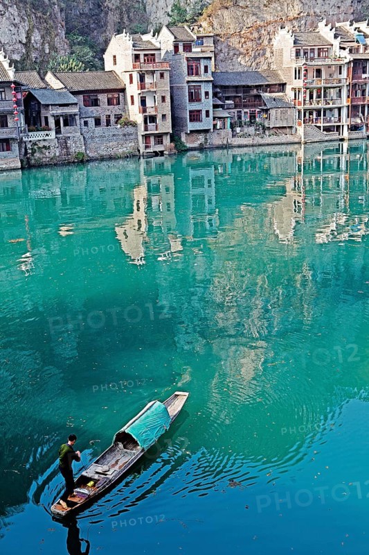 Houses and a fisherman in a boat on the jade-coloured Wuyang River