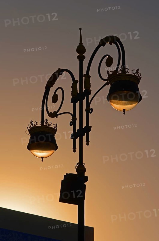 Street lamp back-lit by the setting sun at the Corniche of Muttrah