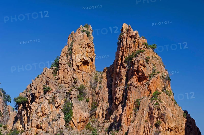 The typical bizarre red rocks of the Calanche of Piana below a blue sky. The Calanche of Piana is in the western part of the island Corsica