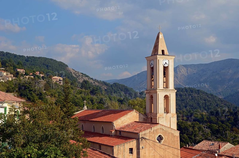 The church of the small village Evisa illuminated by warm evening light surrounded by mountains. Evisa is in the department Corse-du-Sud