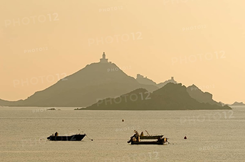 The silhouette of the islands Les Iles Sanguinaires with small boats in the foreground. Les Iles Sanguinaires are in the department Corse-du-Sud
