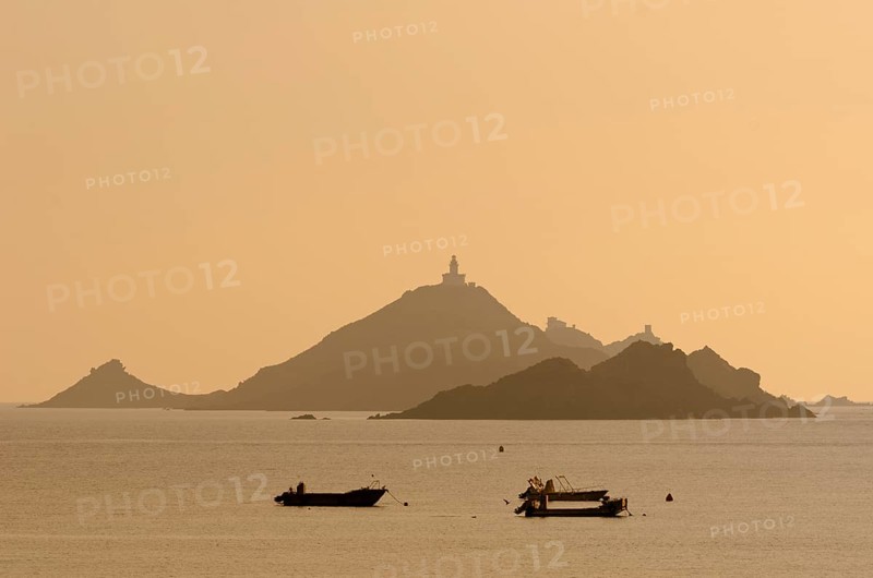 The silhouette of the islands Les Iles Sanguinaires with small boats in the foreground. Les Iles Sanguinaires are in the department Corse-du-Sud