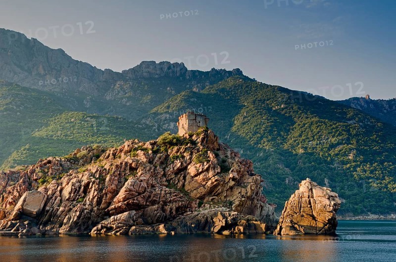 The Genoese Tower of Porto on top of a rocky hill and the Gulf of Porto
