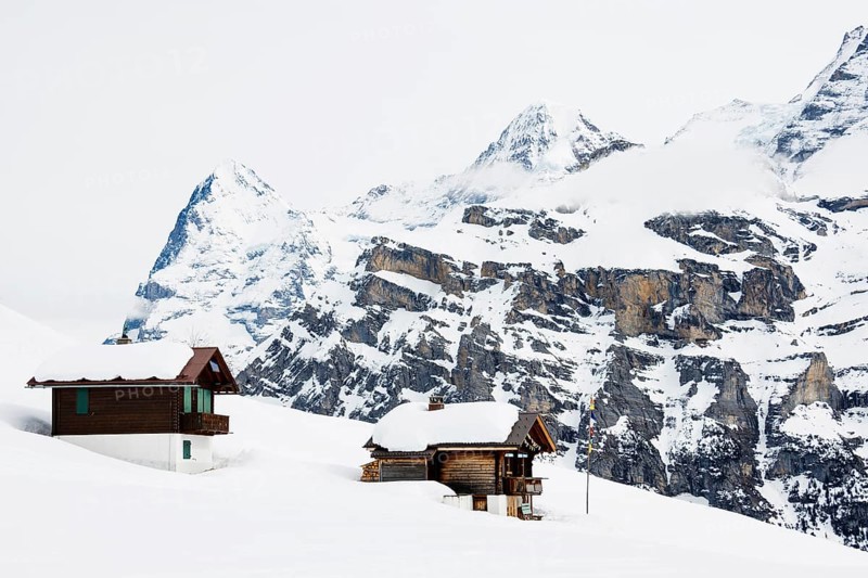 Old log cabins in the Bernese Oberland with Mt Eiger in winter