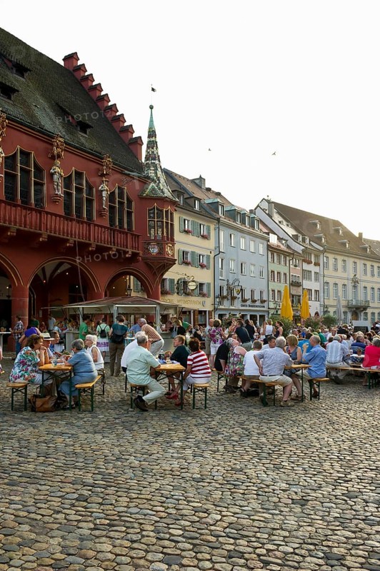 Wine stand and restaurants in front of the Historical Merchants Hall on Muensterplatz square or Cathedral Square