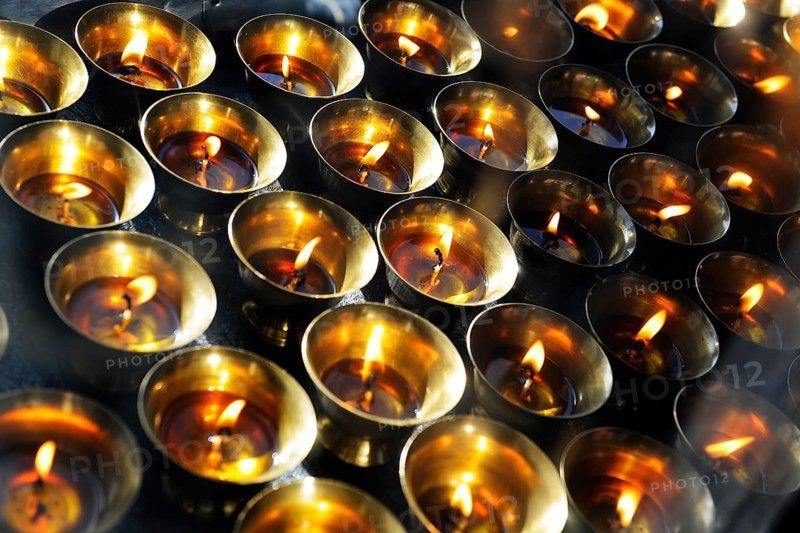 Yak butter lamps burning at a shrine en route to the monastery and temple complex of Taktshang-Lhakang