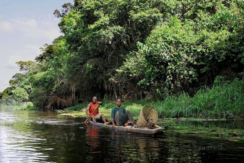 Fisherman travelling with his wife along the Nyong River to set fish traps