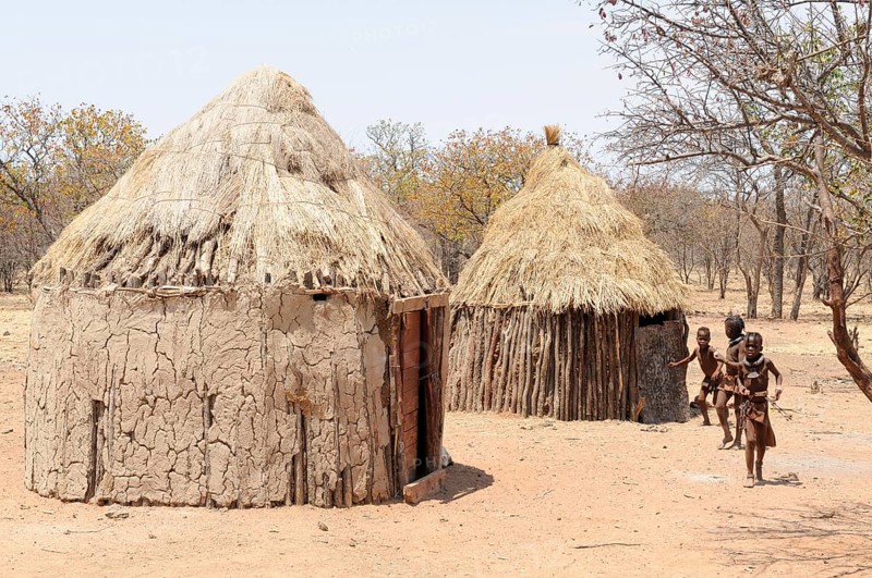 Himba children playing outside Himba huts in a Himba village