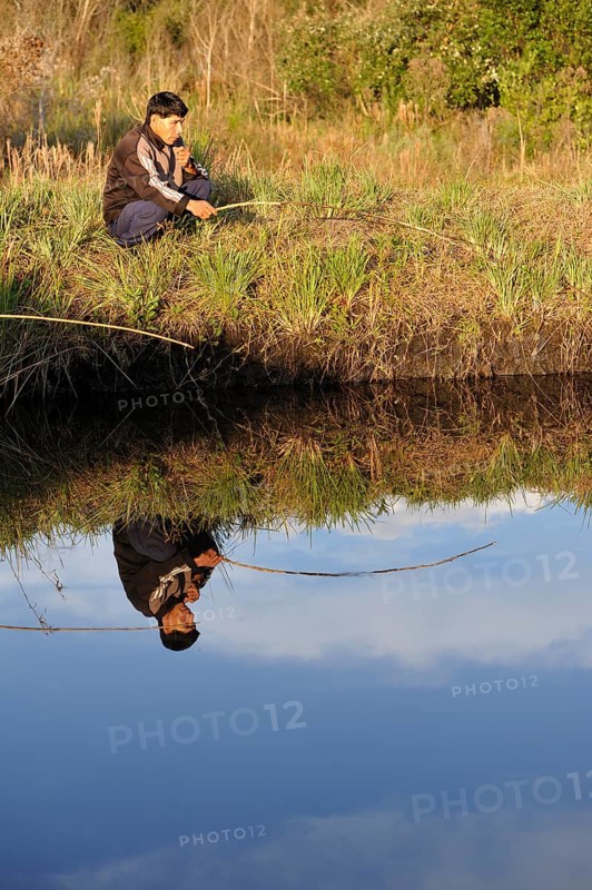 Indigenous man fishing in a pond in the community of Mbya-Guarani Indians