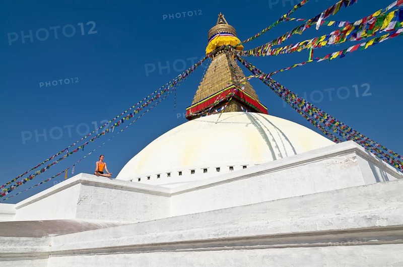 Young woman practicing yoga at the Boudnanath stupa