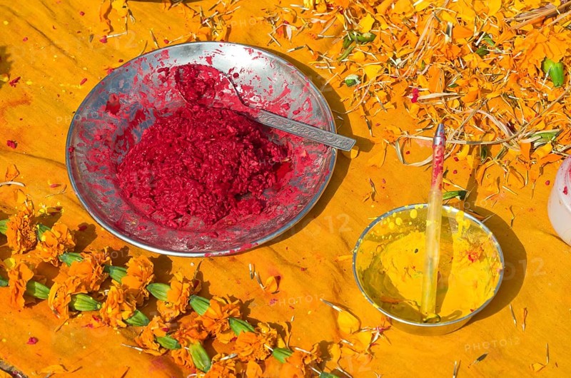 Colourpowder and coloured rice on yellow material to work with as a priest
