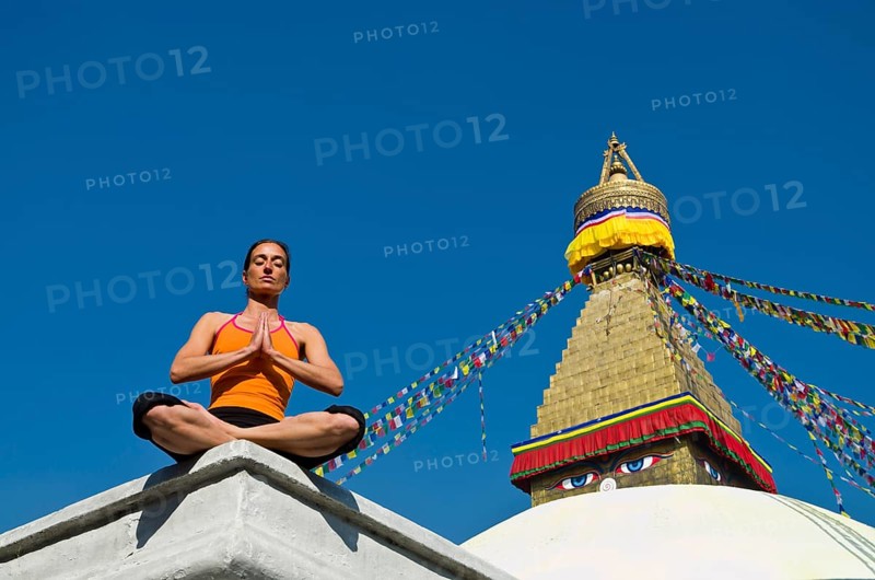 Young woman practicing yoga at Boudnanath stupa