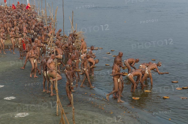 Offering parts of their first meal in their new lives as part of the initiation of new sadhus at the Sangam