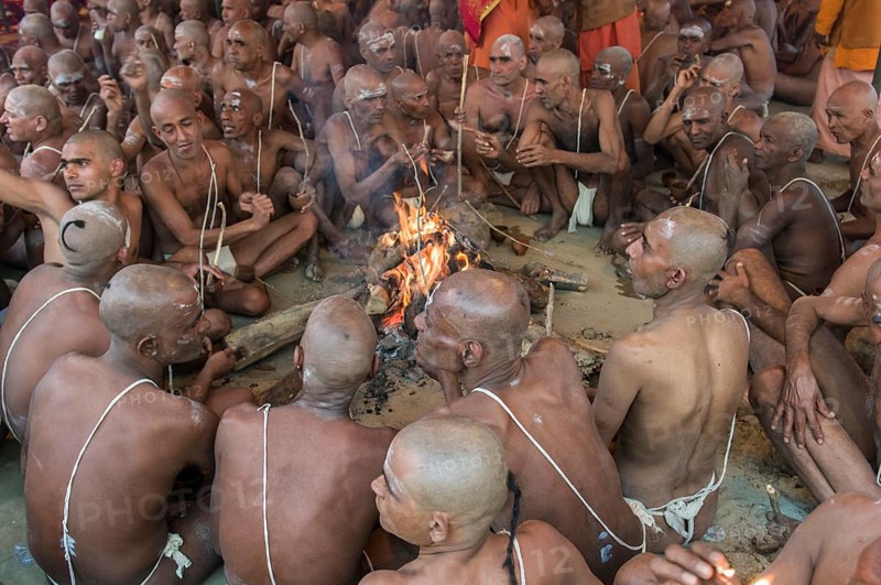 Sitting around a bonfire and chanting mantras as part of the initiation of new sadhus
