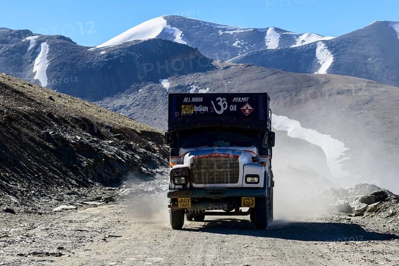 A truck driving on the dusty winding road leading up to Taglang La