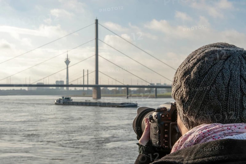 Young woman taking photographs of the Rhine