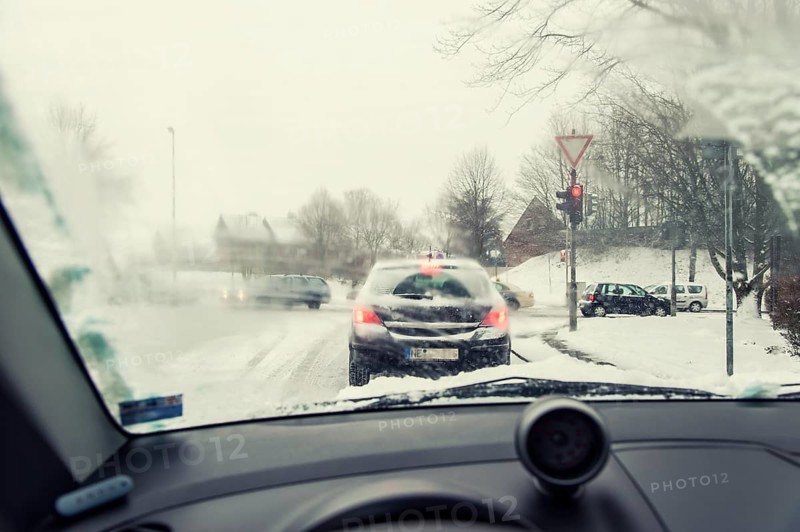 View through the windscreen of a car at red traffic lights at crossroads