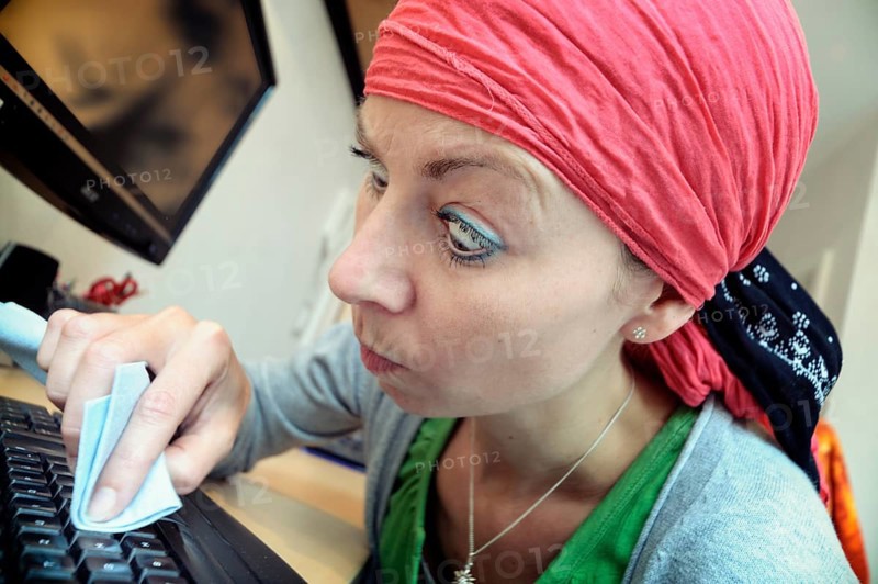 Cleaning lady cleaning a computer keyboard