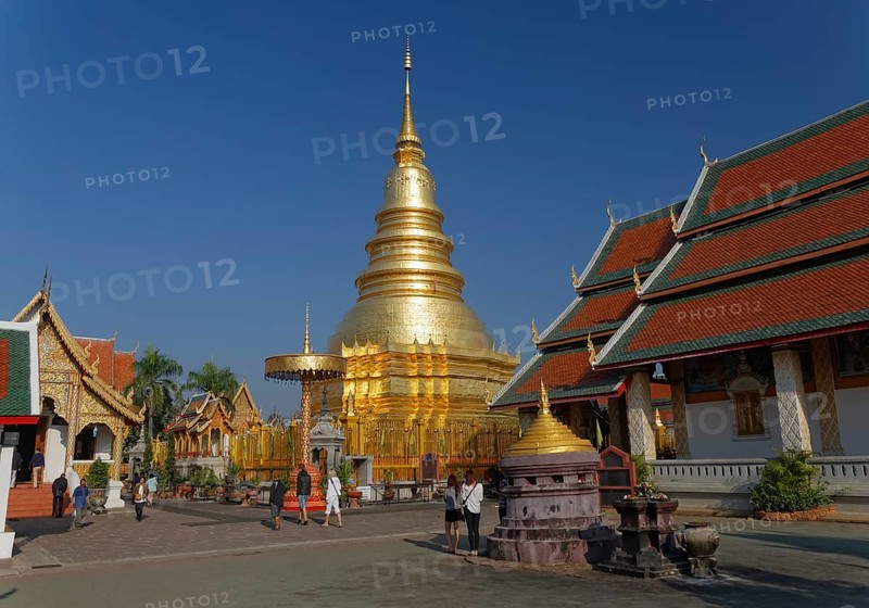 Golden chedi or pagoda with a ceremonial umbrella in the temple complex of Wat Phrathat Hariphunchai Woramahaviharn