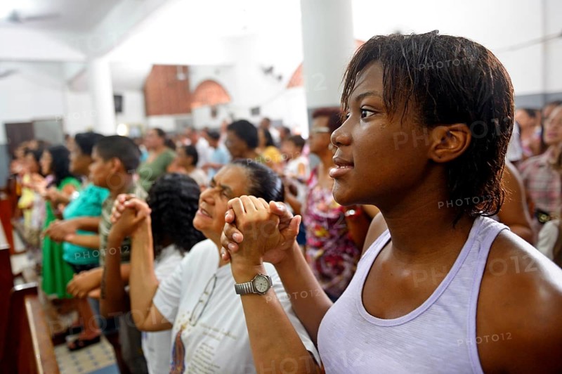 Worshippers holding each other's hands and praying