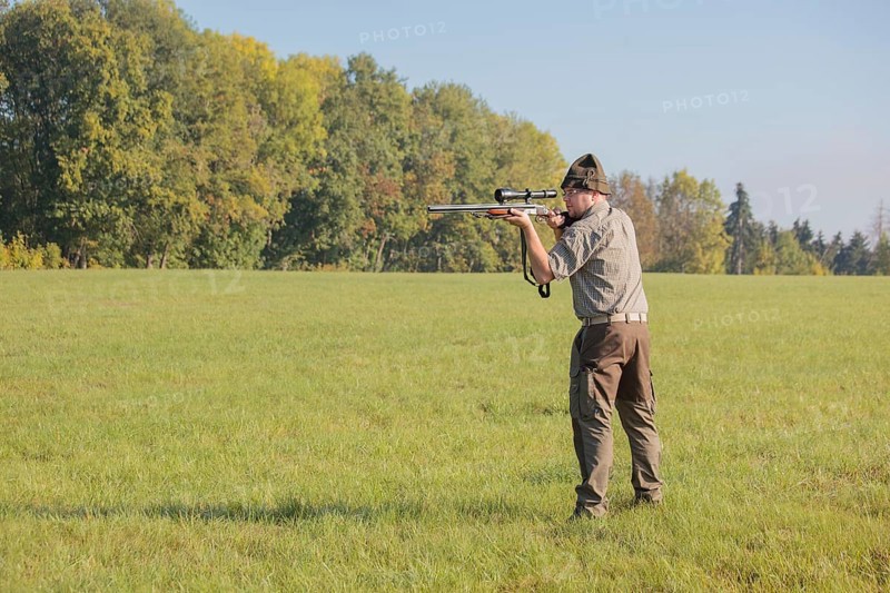 Hunter waiting for game with weapon at the ready