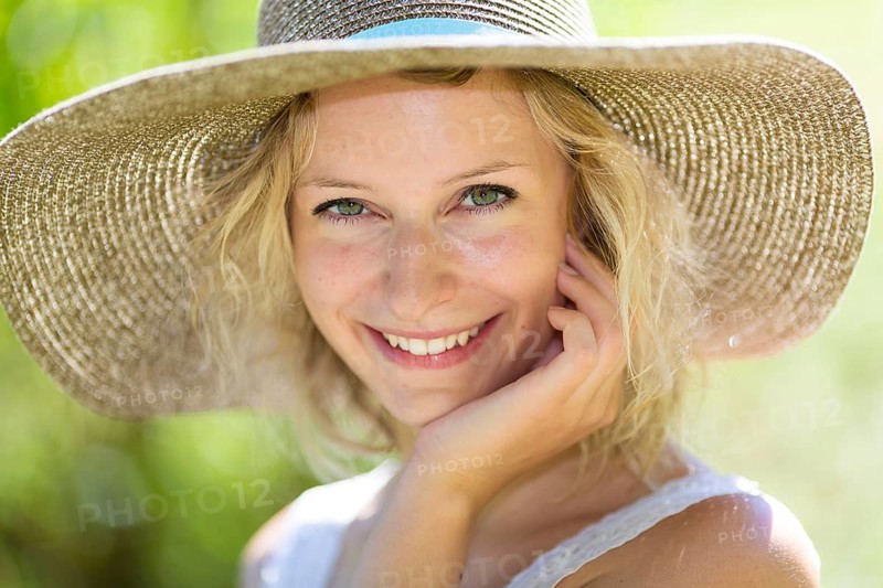 Smiling young woman with summer hat