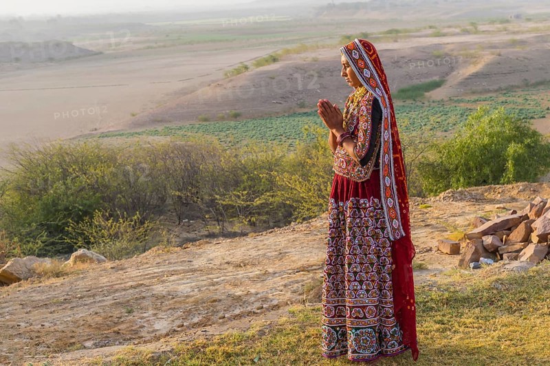Ahir woman in traditional colorful clothes meditating at sunset