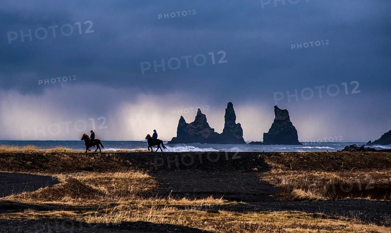 Two horserider riding Icelandic horses on the coast