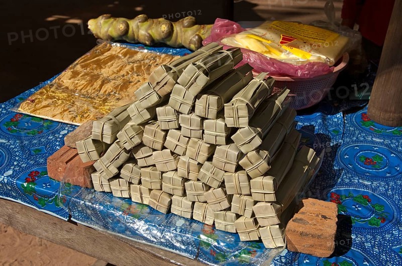 Palm sugar packed in palm leaves for sale at a market stall