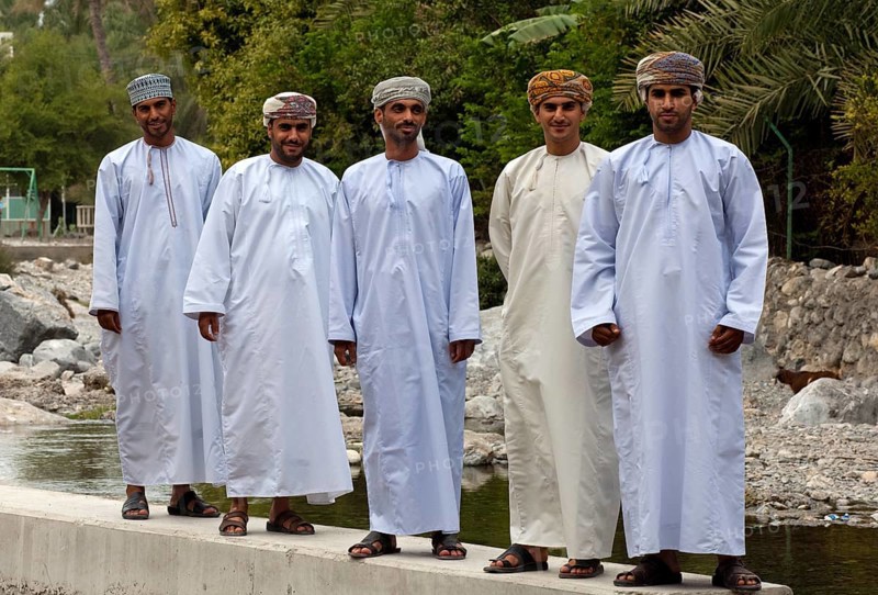 Five young Omani men wearings traditional dishdasha festive clothes during a trip to the hot springs of Ain A'Thawwarah